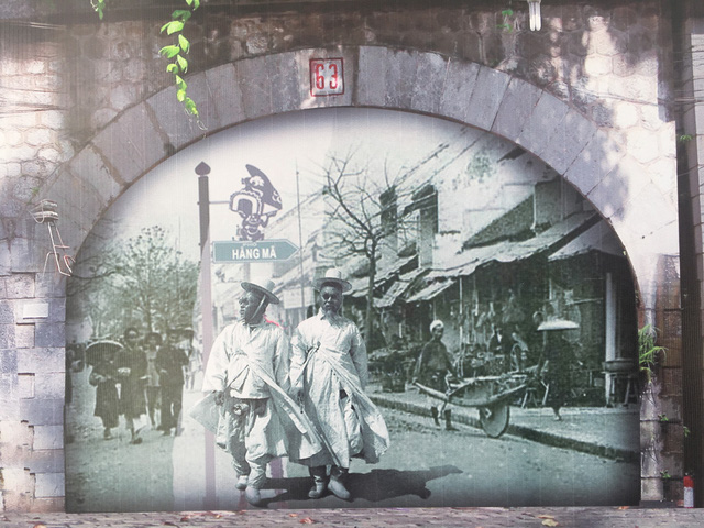 Tác phẩm chung của các hoạ sĩ Việt Nam và Hàn Quốc với hình ảnh hai người đàn ông Hàn Quốc đi trên phố Hàng Mã, Hà Nội